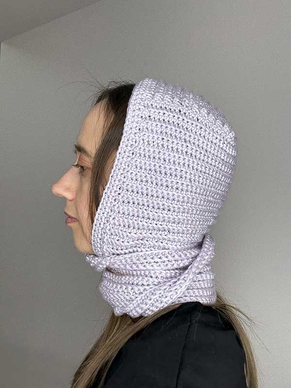 crochet hood style bonnet on the female model - left side view