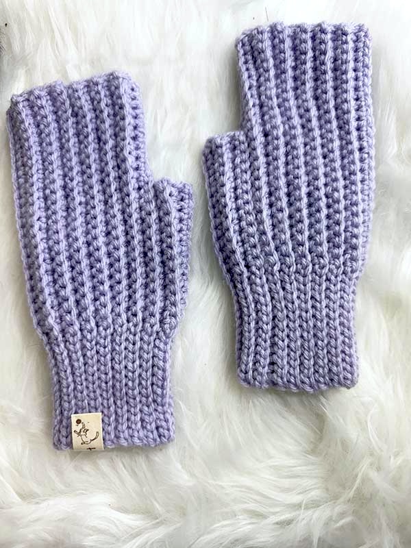 crochet ribbed fingerless gloves on a flat surface with a back side up